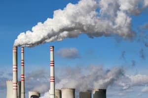 white smoke coming from white and red factory smokestacks