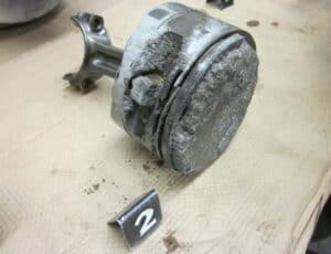 Image of an eroded piston with broken rings and scuffed skirt