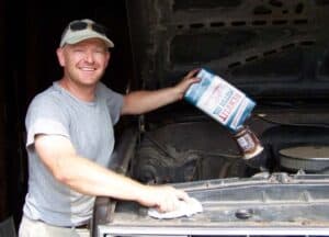 Ryan proudly pouring old Renuzit motor oil into his '84 Chevy.