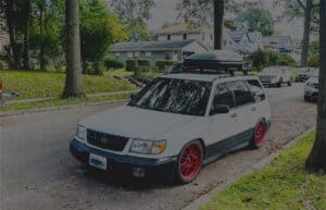 Image of an old Subaru with a clamshell rack on top