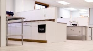 A photo of our laboratory, featuring white cabinetry and stainless steel tabletops, along with a black towel featuring the Blackstone Laboratories logo draped over one of the cabinets.