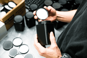Someone holding Blackstone's free oil sample kit in one hand and the lid in the other hand