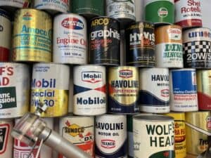 An aesthetically pleasing, brightly-colored stack of vintage oil cans. Brands include Havoline, Wolf's Head, Sunoco, Amoco, Sinclair, HyVis, Union 76, and Phillips 66.