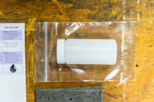 Close-up of a white sample bottle on a ziploc bag