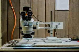 A piece of filter media spread across a lab desk, with a micrscope/camera set up over it.