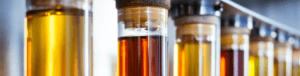 A line of test tubes filled with oil in various colors