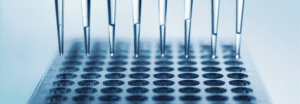 Eight droppers positioned above a rack of test tubes