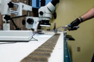 oil filter pleats spread across a lab bench, being inspected and photographed with a micrsocpe.