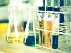 Black and yellow fluids in test tubes in a rack