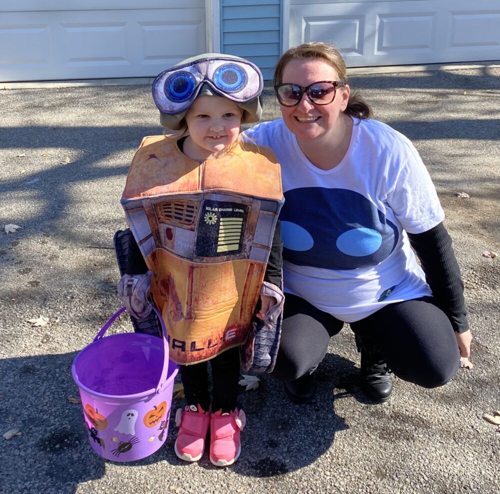 Holli kneeling with her kid in a Halloween costume