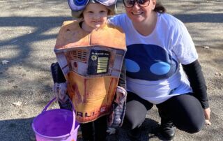 Holli kneeling with her kid in a Halloween costume