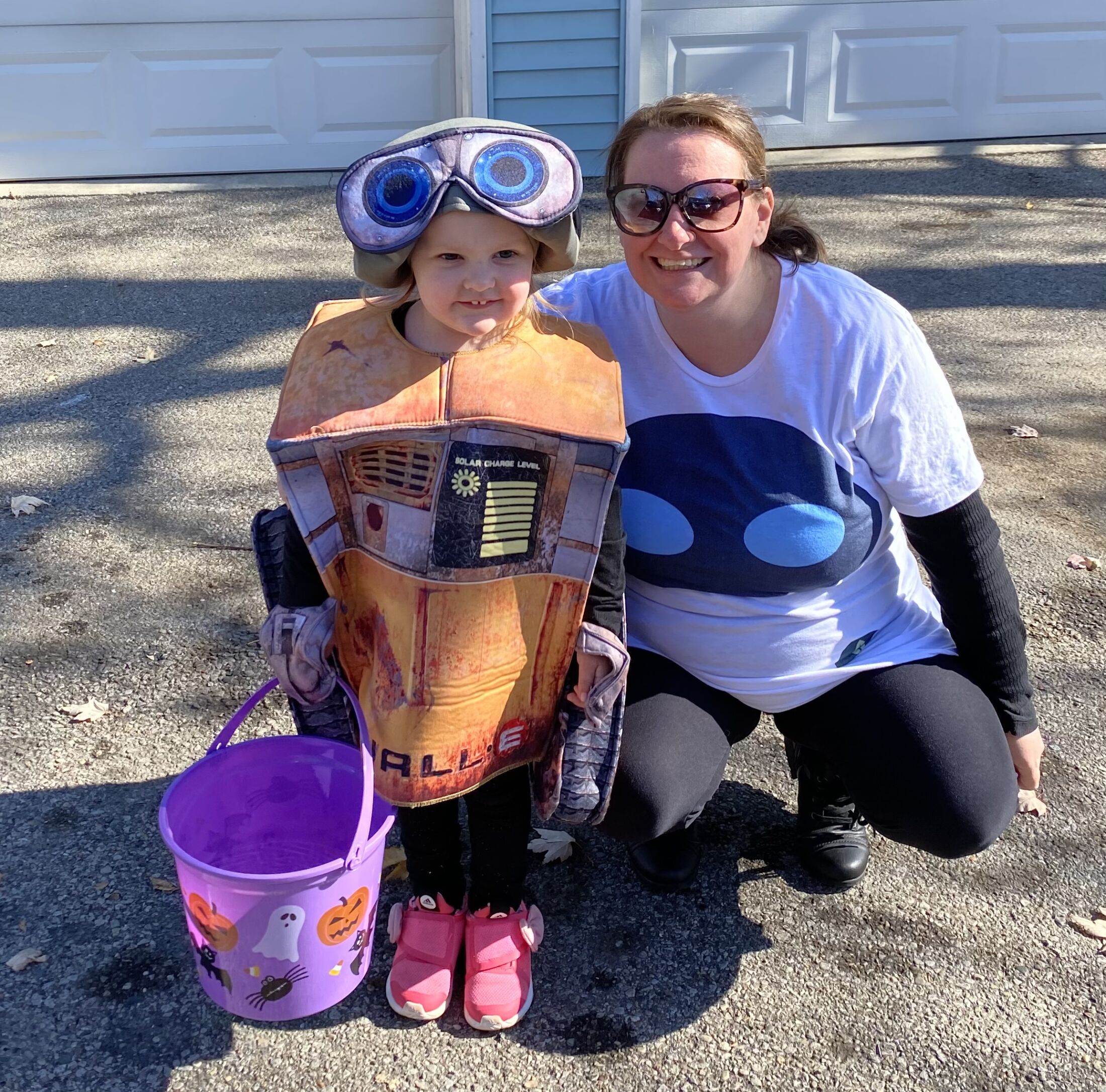 Holli Holli kneeling with her kid in a Halloween costume