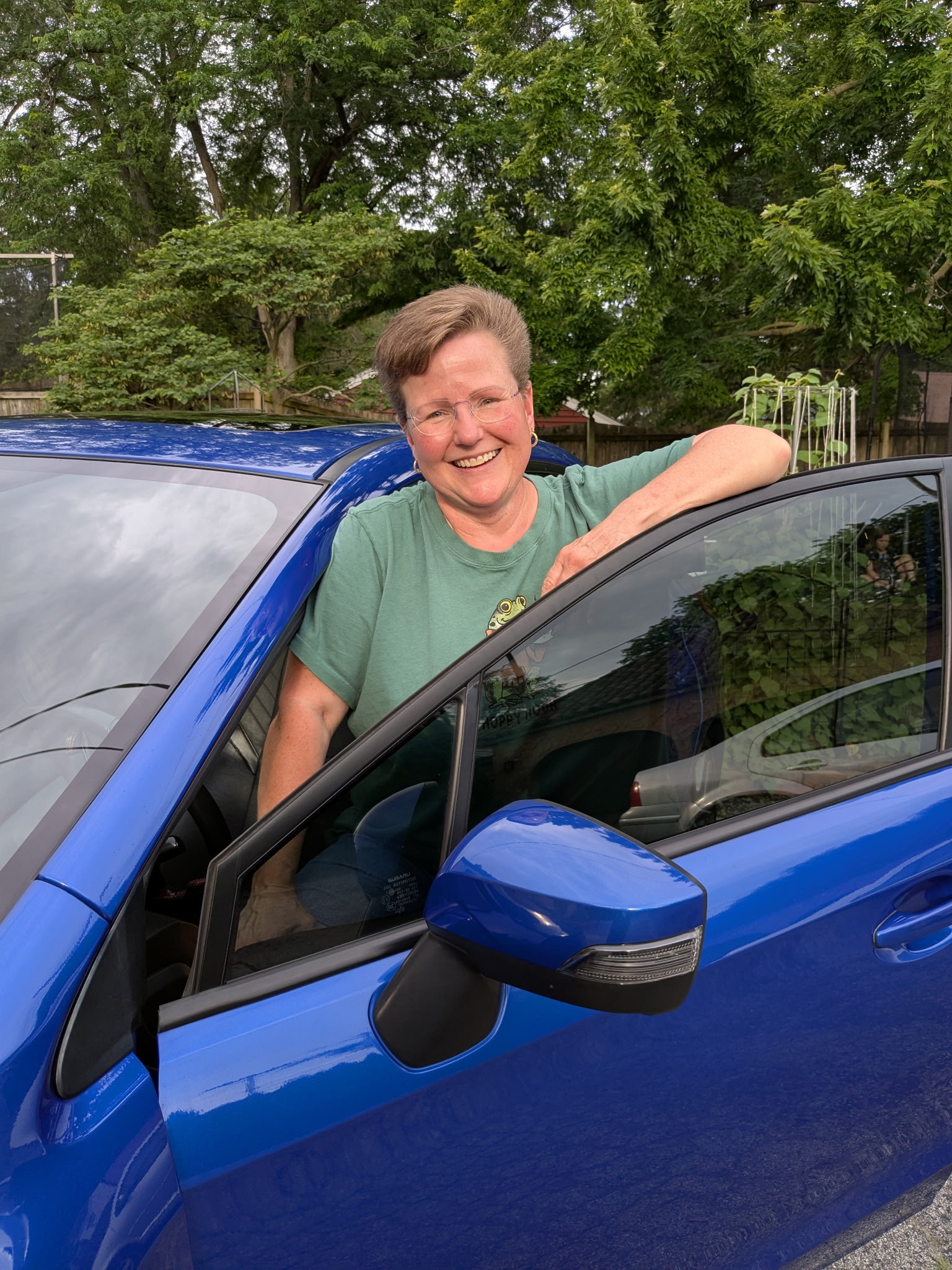 Susan leaning on her car